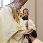 Photo by Kevin J. Kilmer The Most Reverend Joseph M. Siegel, Bishop of Evansville, lays his hands on Deacon Andrew Thomas as he ordains him Saturday, in St. Philip Church, Mount Vernon, Ind., during the Rite of Ordination.