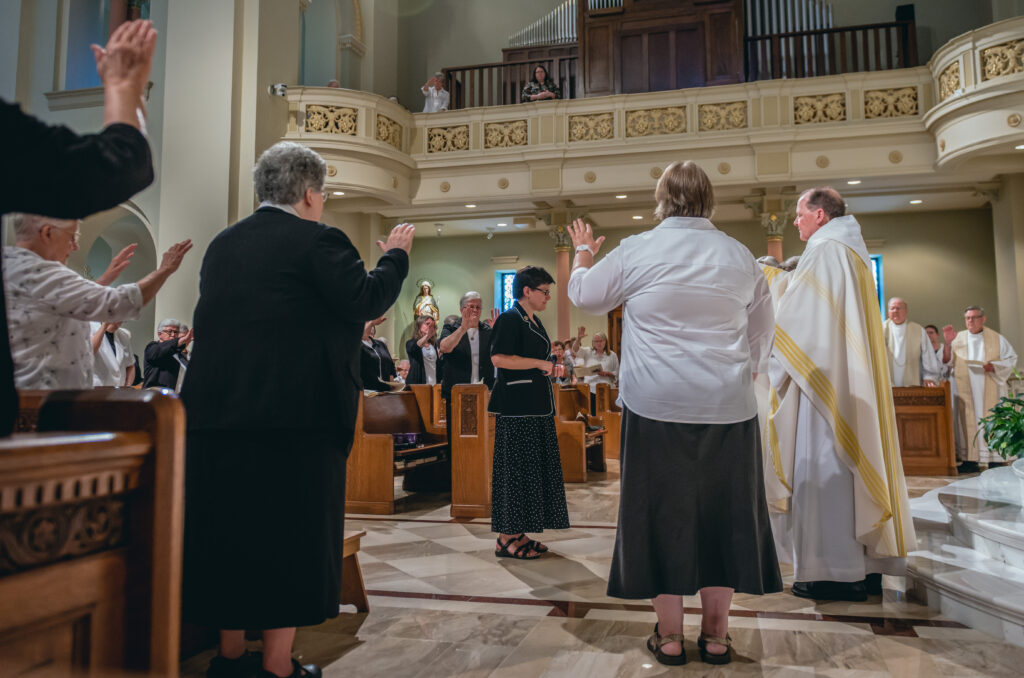 Benedictine Rt. Rev. Kurt Stasiak, right, leads a prayer of blessing
for Benedictine Sister Anita Louise Lowe as she is installed as the
14th prioress during a July 13 Mass at Monastery Immaculate
Conception in Ferdinand. At right in the background are Father
Joseph Ziliak and Father Ray Brenner, retired priests of the
Diocese of Evansville. Father Bernie Lutz, retired priest of the diocese, also attended but is not pictured.