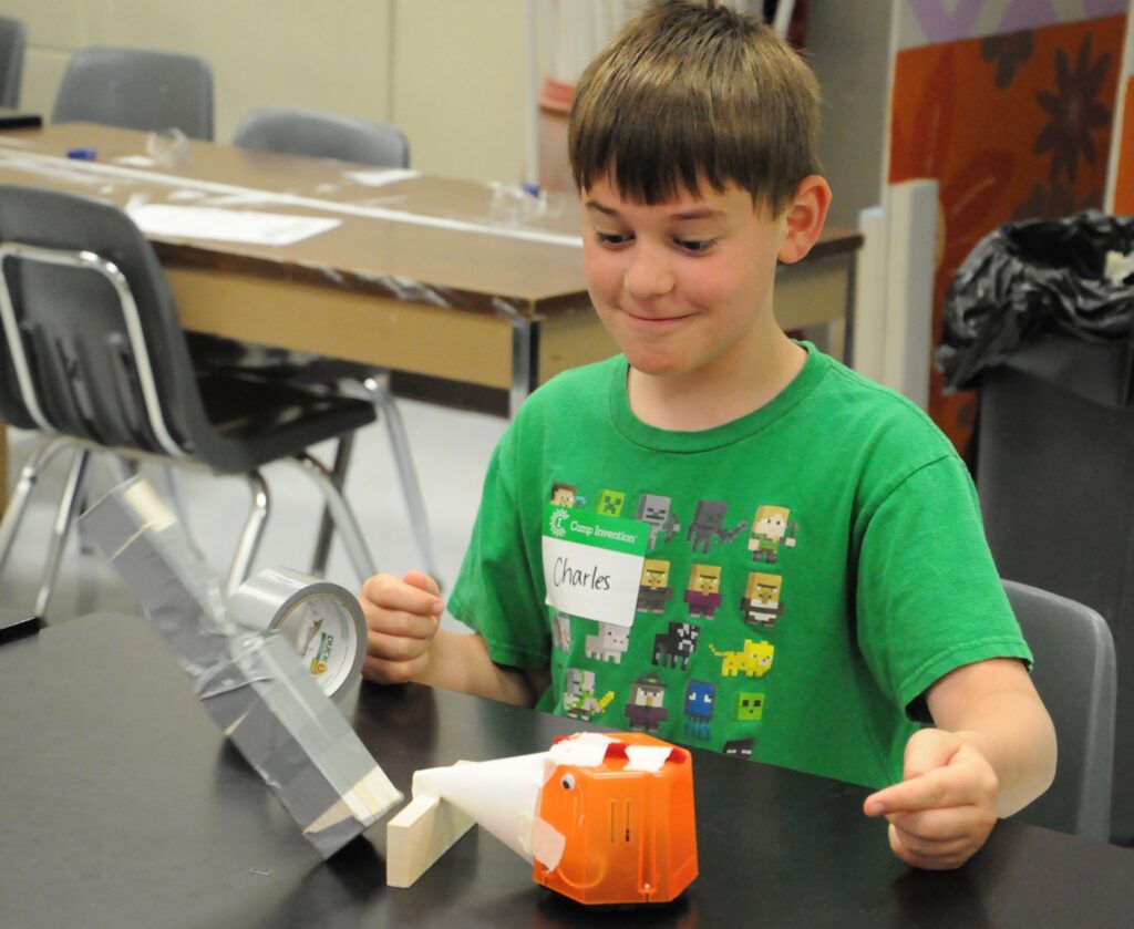 Corpus Christi fourth-grader Charles Baker tests the bulldozer robot he created to see if it will knock over a tower he built.