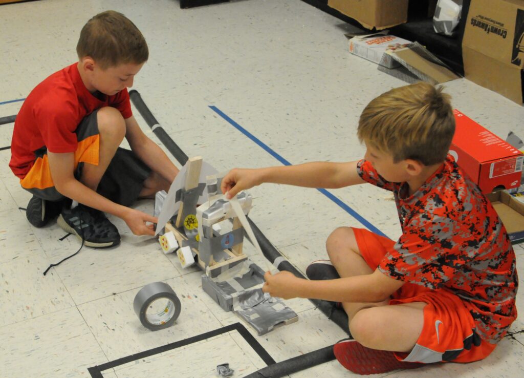 Good Shepherd Catholic School fourth-graders John Pietruszkiewicz and Gus Theby build a ship during Camp Invention: Supercharged.
