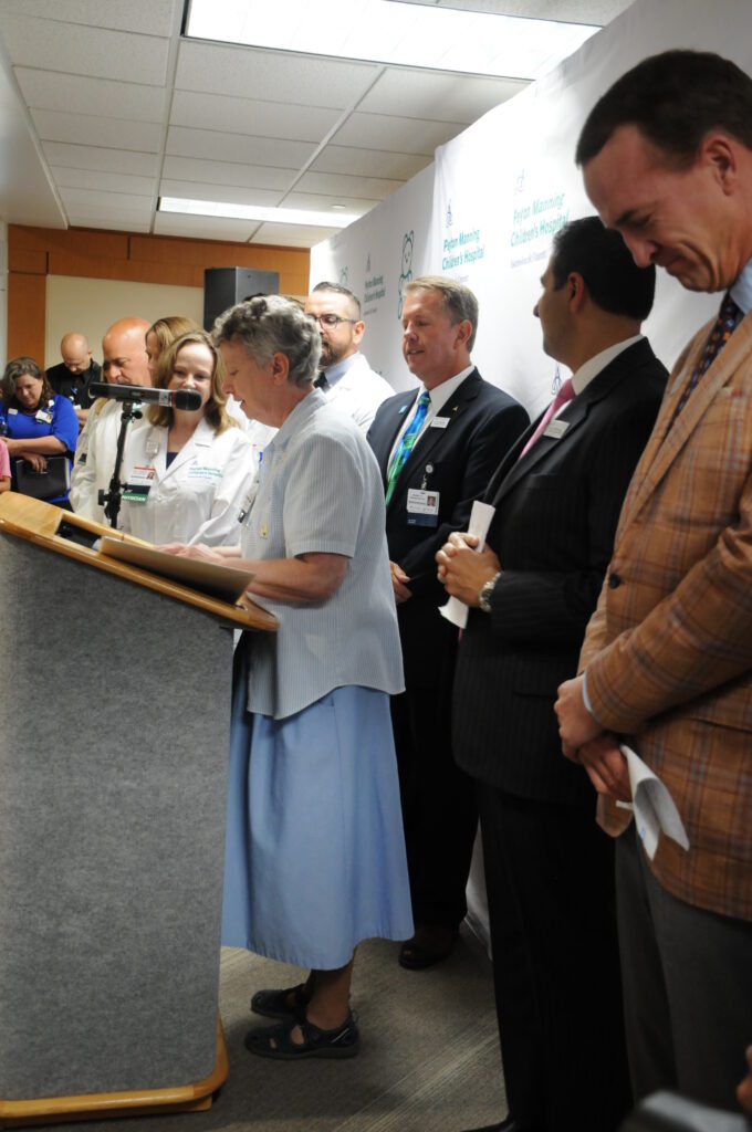 Franciscan Sister Jane McConnell, standing at podium, head of mission integration for St. Vincent Evansville, led the group in prayer on Aug. 14 before the news conference.