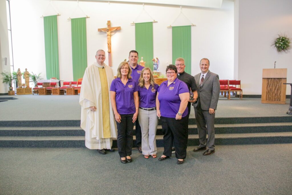 Holy Trinity School in Jasper received the Catholic Educator Innovator Award after the Back-to-School Mass on Aug. 2 at Good Shepherd Parish. Pictured are Charmaine Oxford, front row left, teacher; Jenna Seng, Holy Trinity Central Campus principal; Benedictine Sister Becky Mathauer, teacher; Bishop Joseph M. Siegel, back row left; Jon Temple, Holy Trinity East Campus principal; Father Gary Kaiser, pastor of Precious Blood Parish in Jasper; and Dr. Daryl Hagan, diocesan schools superintendent.