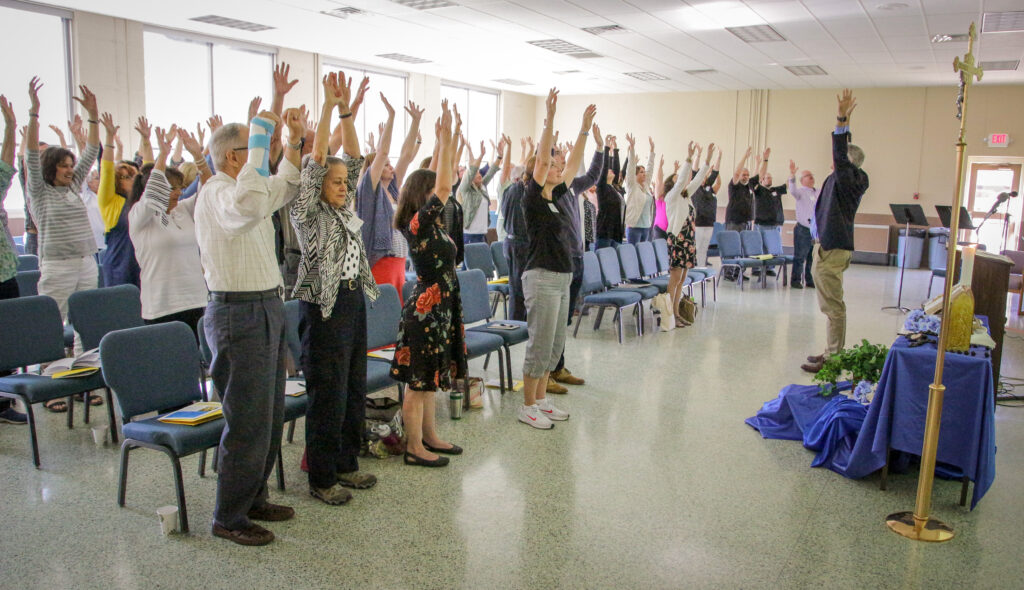 Dr. Tim Hogan, right, leads Formation Day attendees through a breathing exercise designed to have
a calming effect. “We all have to be open to receiving God,” he said.