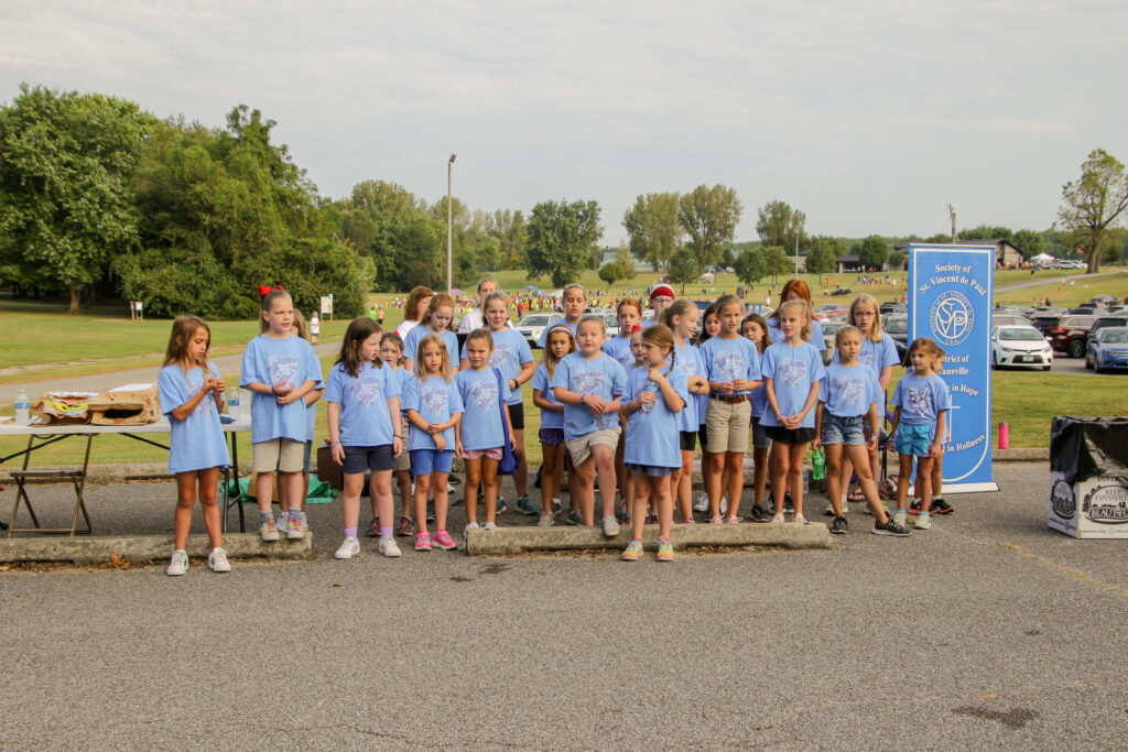 Thirty-eight members of American Heritage Girls Troop IN5301 from Evansville’s Resurrection Parish sang before the Sept. 21 Friends of the Poor walk began. The Message photo by Tim Lilley