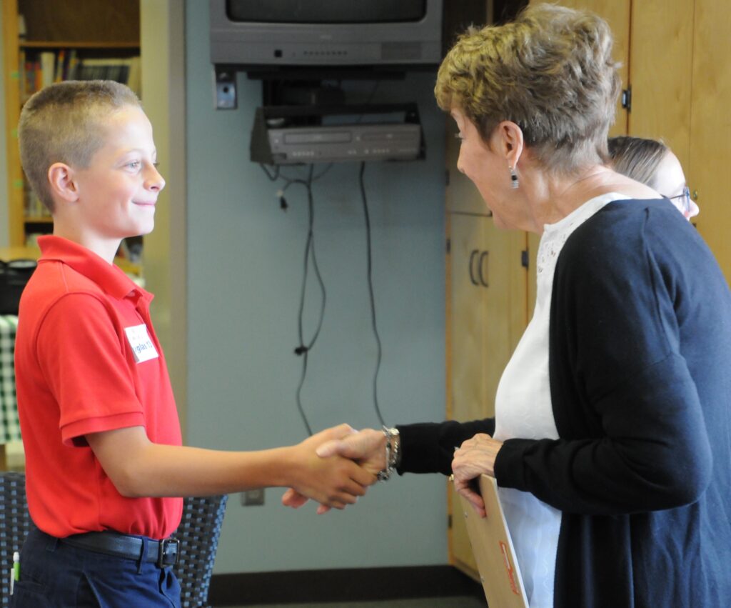 Nancy Bizal, retired educator, mingles with Saint Wendel Catholic School fifth-grader Douglas Stofleth on Oct. 10 during a task for the S.W.I.R.L. competition. Bizal offered Stofleth advice on how to improve his handshake.
The Message photo by Megan Erbacher