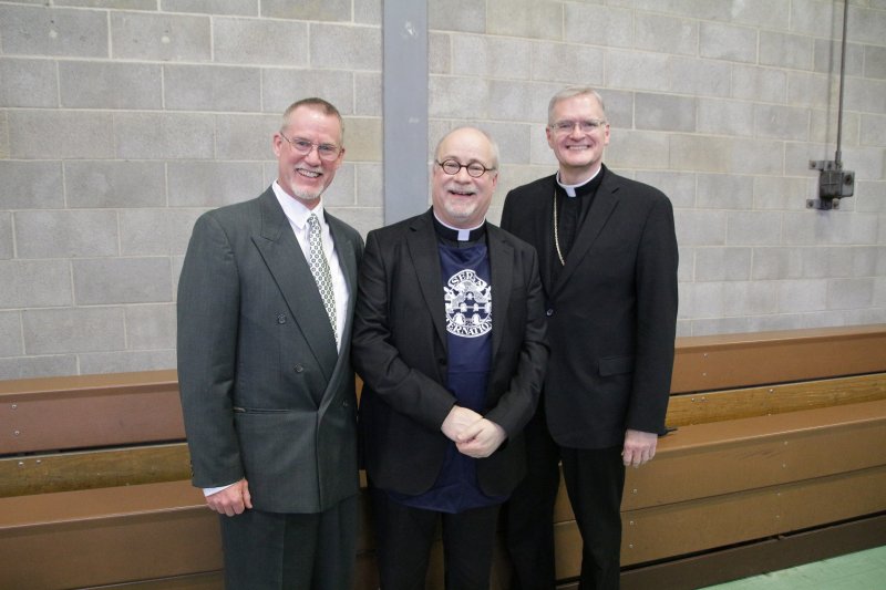 Benedictine Father Denis Robinson of Saint Meinrad wears the Serra Club apron he received from club president John East, left. Bishop Joseph M. Siegel joined them for the photo. The Message photo by Tim Lilley