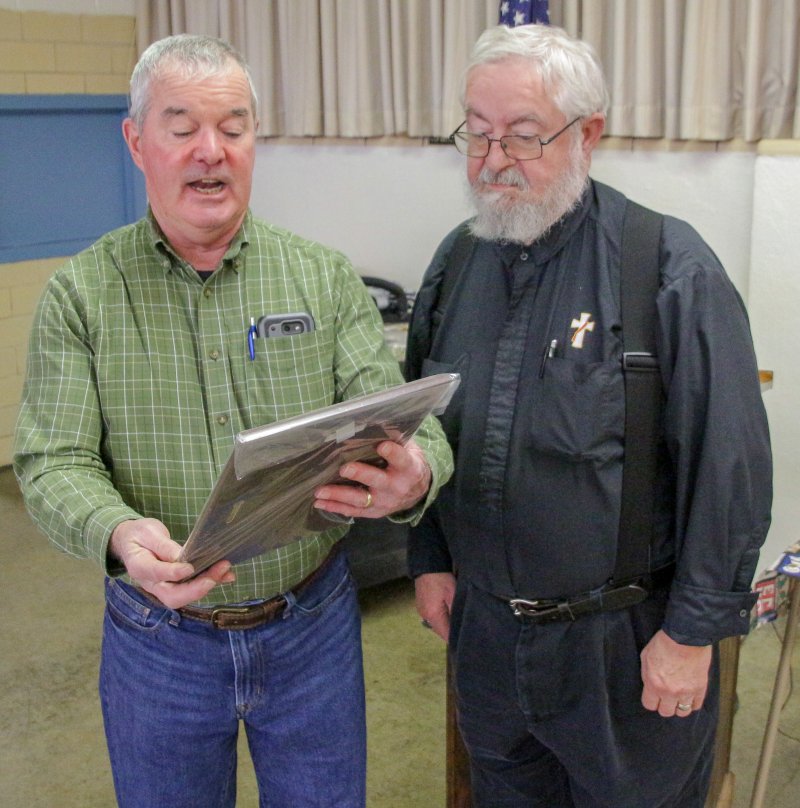 St. Clement parishioner and Knight of Columbus Dennis McVey, left, reads the inscription on the plaque Deacon Thomas Lambert received in recognition of his service to the community through WESK. The Message photo by Tim Lilley