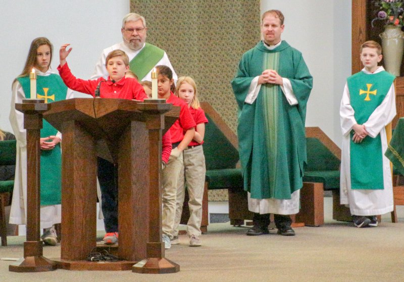 Holy Redeemer second-grader Hayes McCure offers a petition during a Jan. 30 School Mass at the parish. He and some of his classmates offered petitions.. The Message photo by Tim Lilley