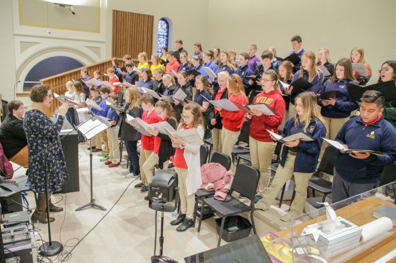 Led by Laura Litwiler of Washington Catholic High School, at the keyboard, and her sister Heidi, of Rivet High School, students from each of the 26 diocesan Catholic schools served as the choir for the Mass. The Message photo by Tim Lilley