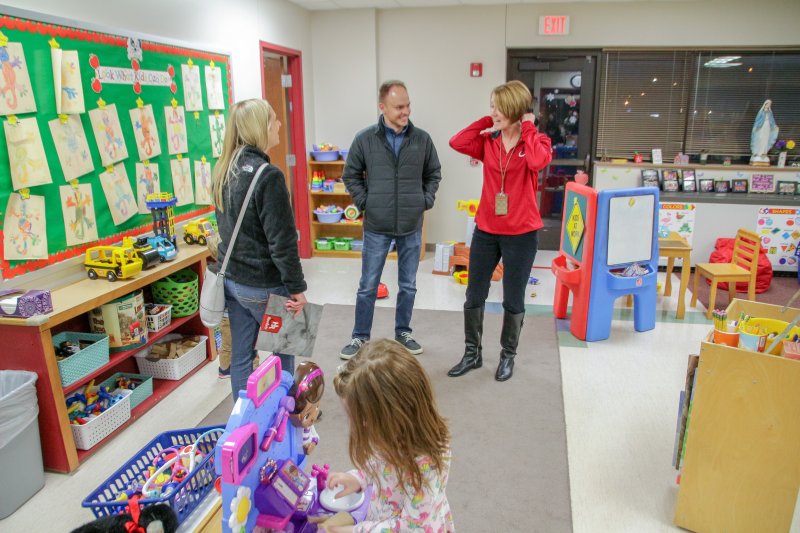 Holy Redeemer Preschool Director Amy Daunhauer, in red, visits with a prospective family. The Message photo by Tim Lilley