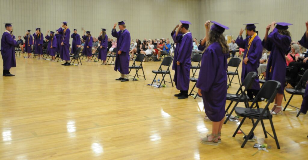 Rivet High School Class of 2020 President Noah Donovan, far left, leads his peers as they move their tassels to signify their status as high school graduates. The Message photo by Megan Erbacher