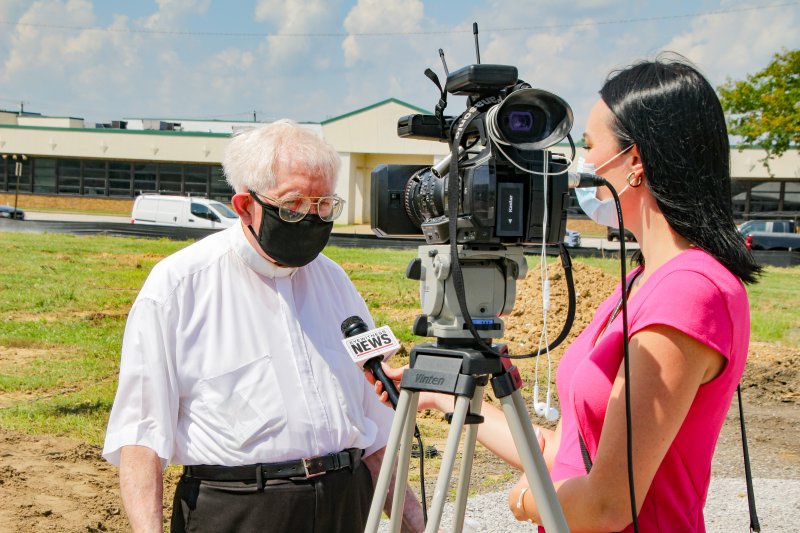 Father Ted Tempel speaks with Eyewitness News reporters Joylyn Bukovac during the Aug. 10 blessing and groundbreaking for St. Theresa Place. The Message photo by Tim Lilley