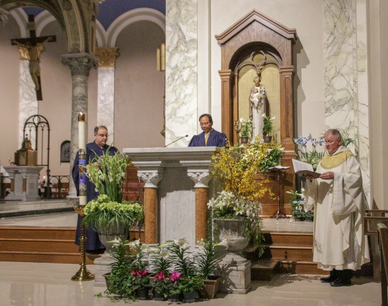 Cathedral Director of Music Jeremy Korba, left, parishioner Mark Valenzuela and Benedictine Father Godfrey Mullen, rector of the cathedral, sing the Easter Proclamation (Exsulset) as the Mass begins. The Message photo by Tim Lilley