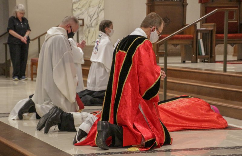 Bishop Siegel prostrates himself before the altar at the beginning of the celebration. The Message photo by Tim Lilley