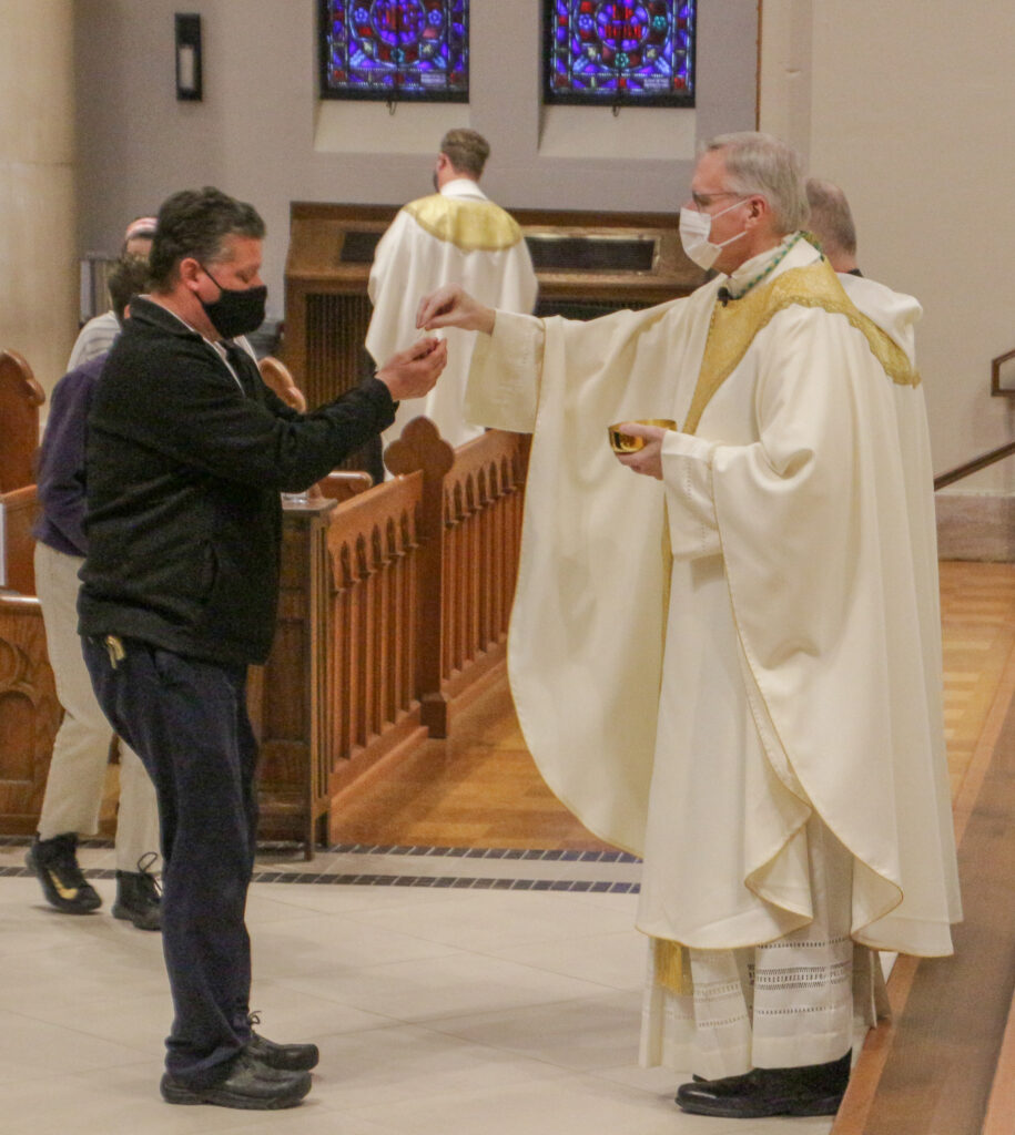 David Memmer, left, principal of Annunciation School’s Holy Spirit Campus in Evansville,
receives Holy Communion from Bishop Siegel. The Message photo by Tim Lilley