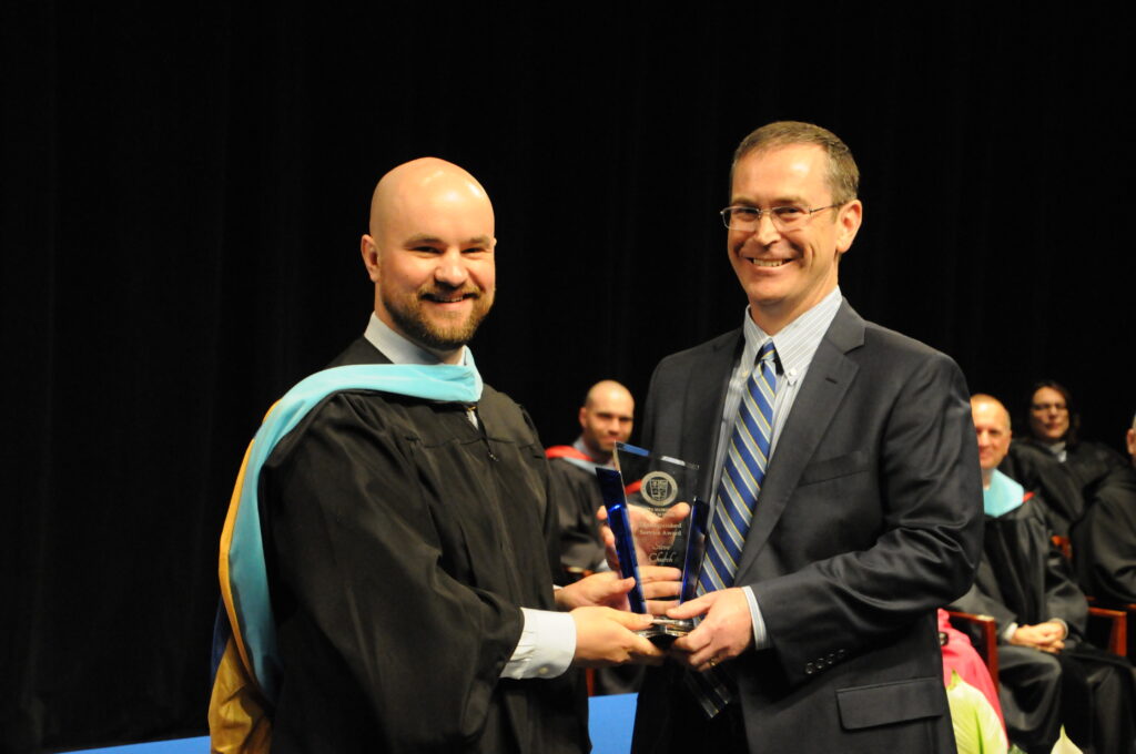 Steve Church, right, accepts the 2022 Reitz Memorial High School Distinguished Service Award
from school president Christian Mocek. Before the award presentation, Mocek gave a brief
introduction of the 37th recipient of the award. Church met his wife of 29 years, Stacey, through
some of his University of Evansville soccer teammates. The couple have four daughters, three of
whom are Reitz Memorial graduates, with the fourth intended to graduate next year. In 2015,
Church joined the President’s Council at Reitz Memorial, and he has served the past two years as
chairperson. In that time, Mocek said Church has been an invaluable member, offering
leadership, supporting various initiatives and ensuring the school has a strong foundation for the
future. When asked what it means to receive the award, Church said it is truly an honor, a
privilege and humbling. Reitz Memorial held its Commencement ceremony for the class of 2022
May 22 at the Old National Events Plaza in Evansville. The Message photo by Megan Erbacher